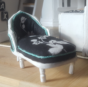 Miniature chaise relaxing outside a kitchen =D